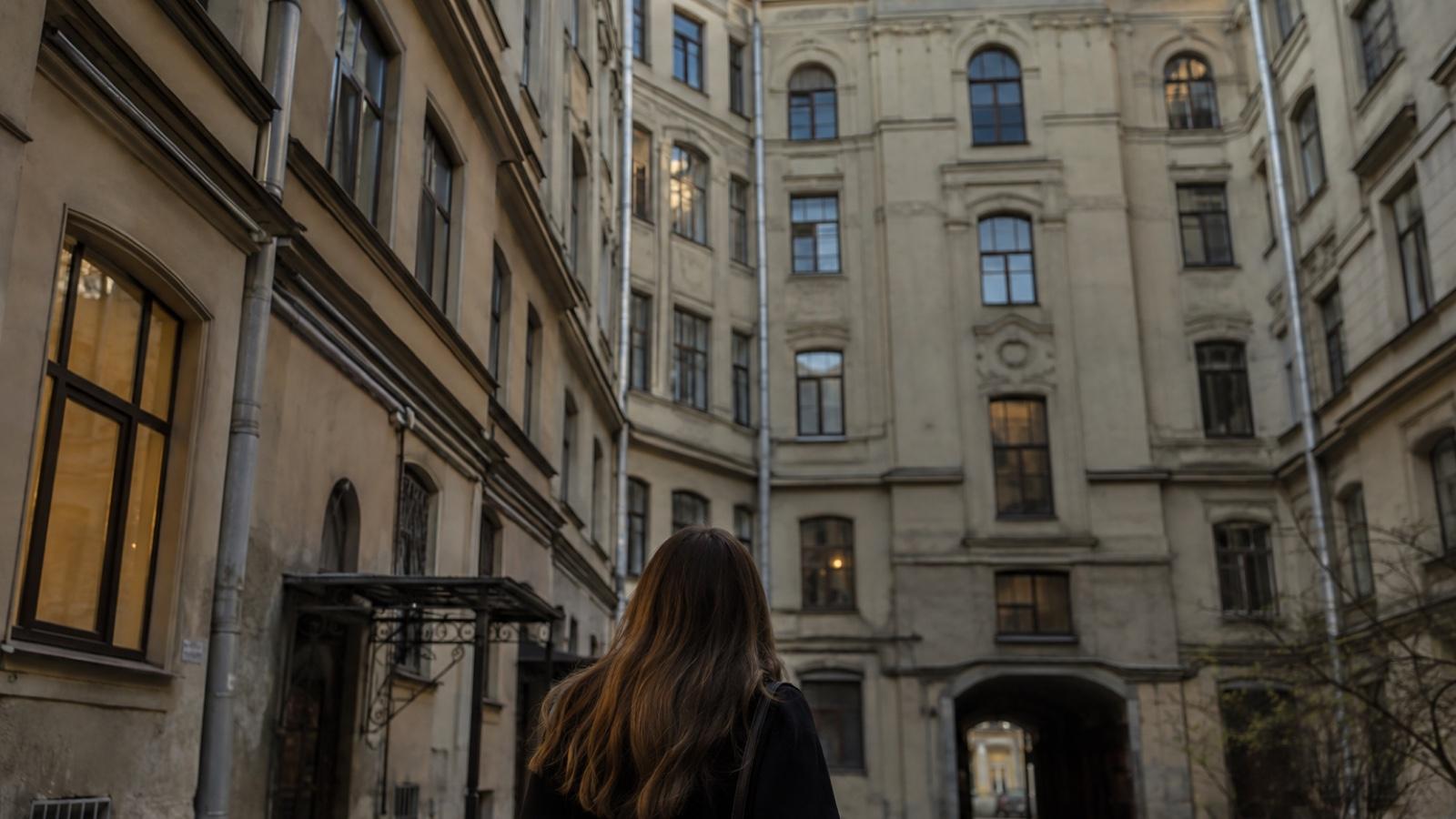 Как узнать собственника квартиры: покупательница во дворе старого дома в Петербурге